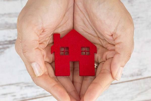 small clay red house in hand